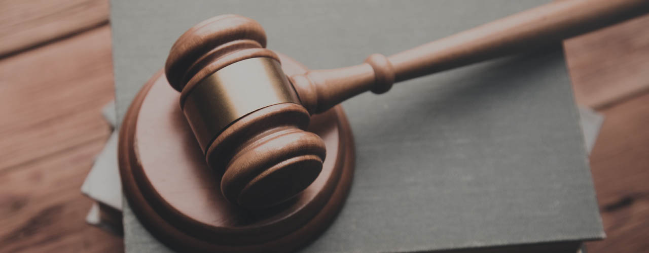 A gavel resting on a stack of books seen from the top.