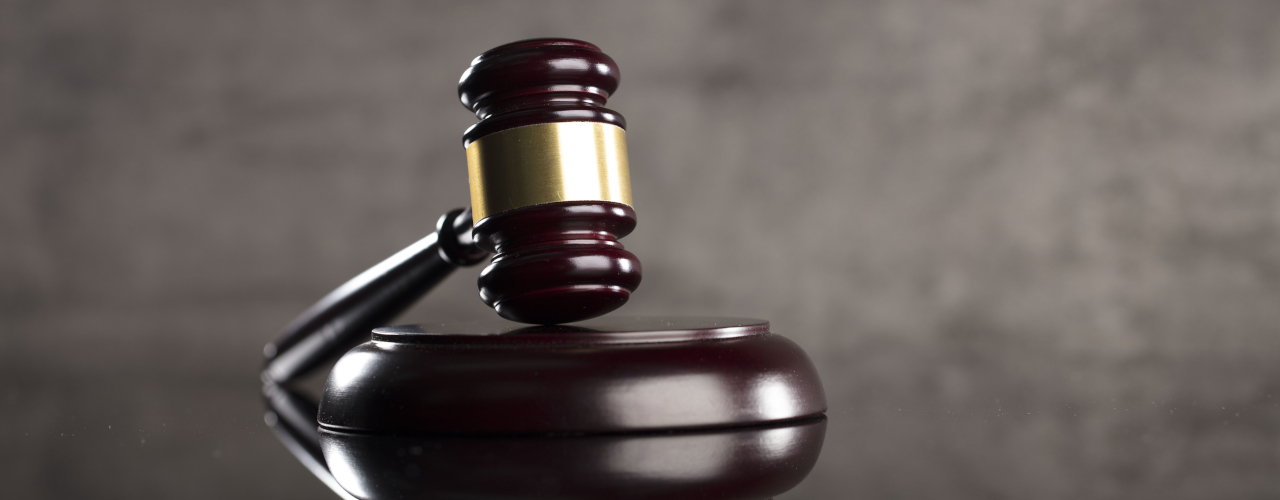A gavel sitting on a sounding block.